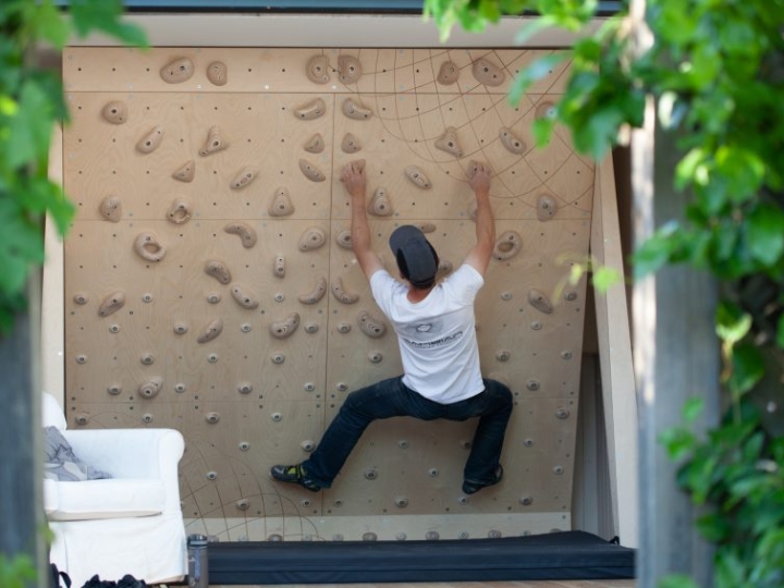 climbing wall pictured at end of garden in summer house with climber on a circuit problem